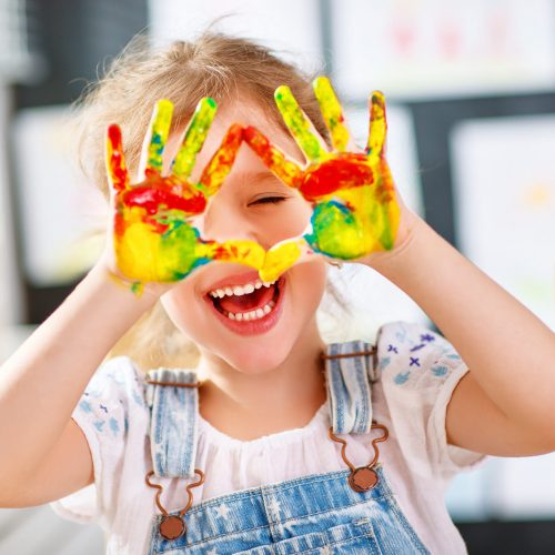 funny child girl draws laughing shows hands dirty with paint happy funny child girl draws laughing shows hands dirty with paint